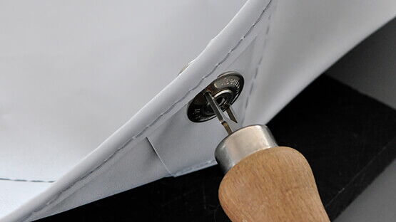 Autosattlerei Freier – An einer neuen Hafen&shy;plane gehört selbst&shy;ver&shy;ständ&shy;lich auch jeder Ver&shy;schluss&shy;knopf sorg&shy;fältig fest&shy;gezogen.